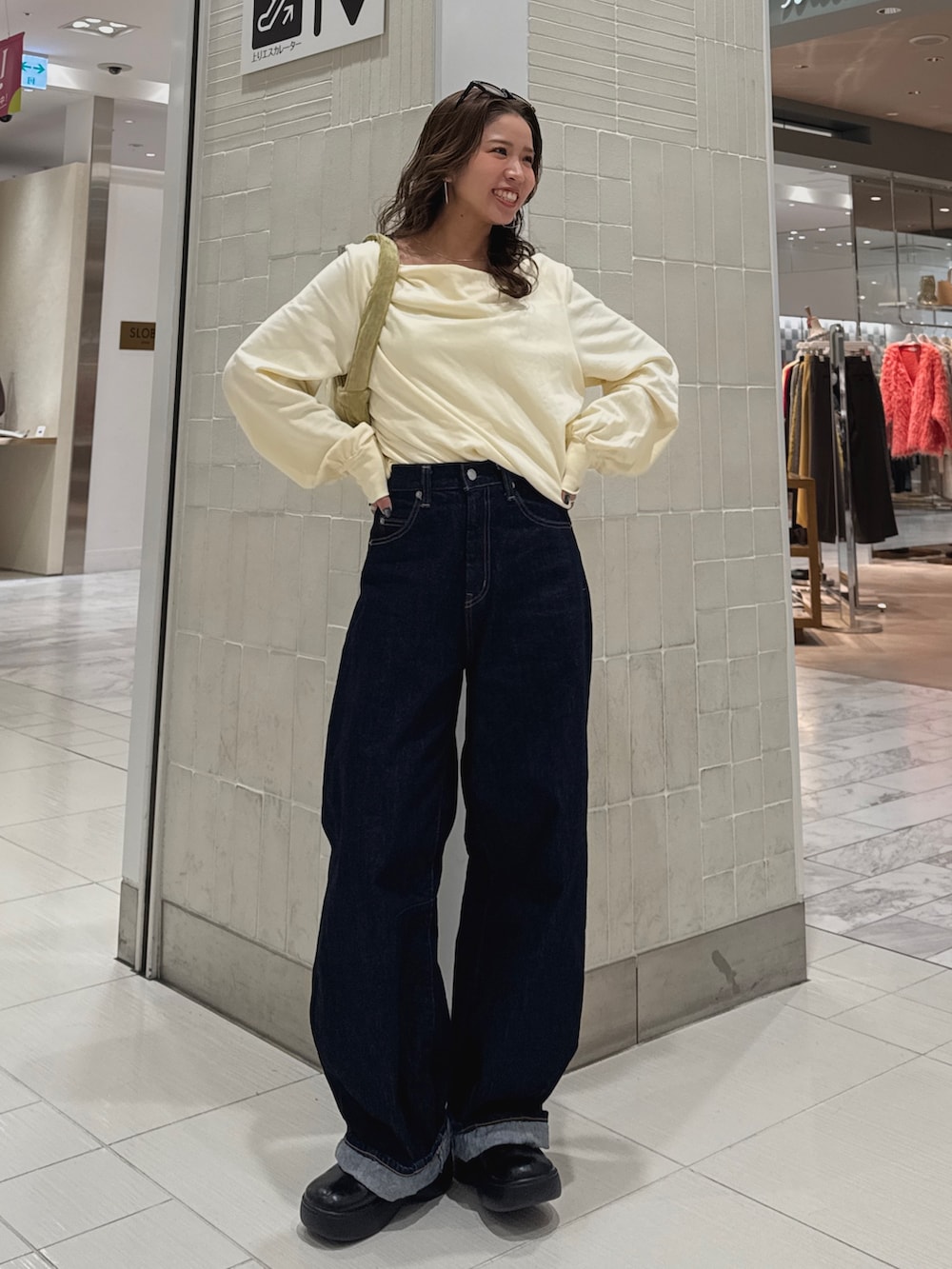 ブルー系のデニムパンツ、ホワイト系のTシャツ/カットソー、グリーン系のハンドバッグを着用したレディースの冬コーディネートの3枚目の写真