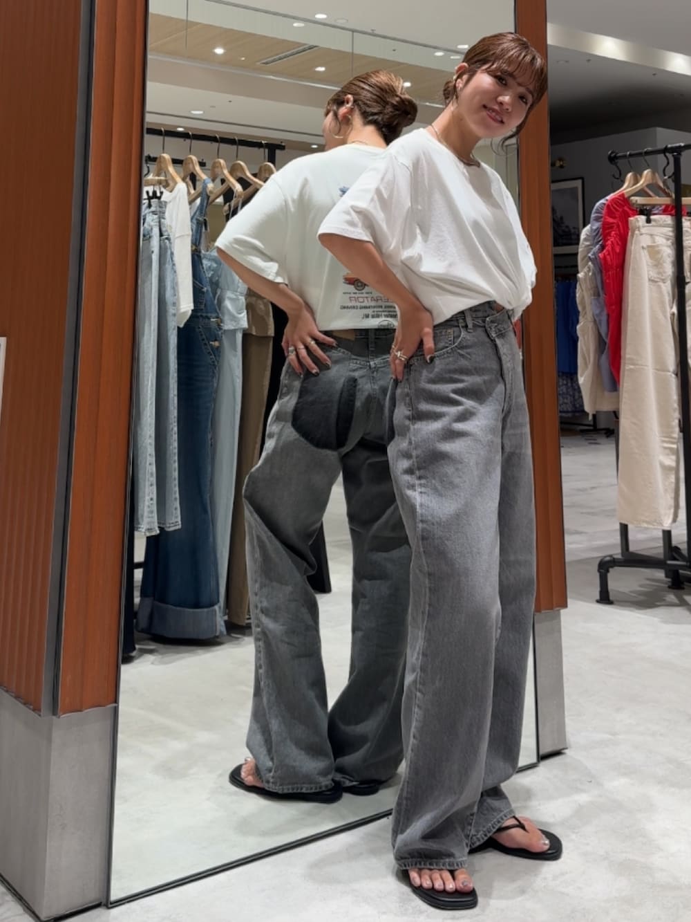 ホワイト系のTシャツ/カットソー、ブラック系のデニムパンツ、ブラック系のサンダルを着用したレディースの夏コーディネートの2枚目の写真