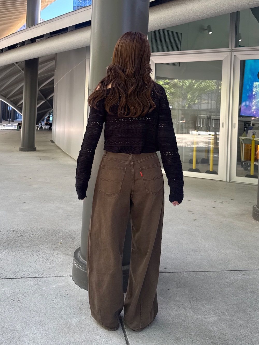 ブラウン系のデニムパンツ、ブラック系のその他シューズ、ブラック系のニット/セーターを着用したレディースの秋コーディネートの5枚目の写真