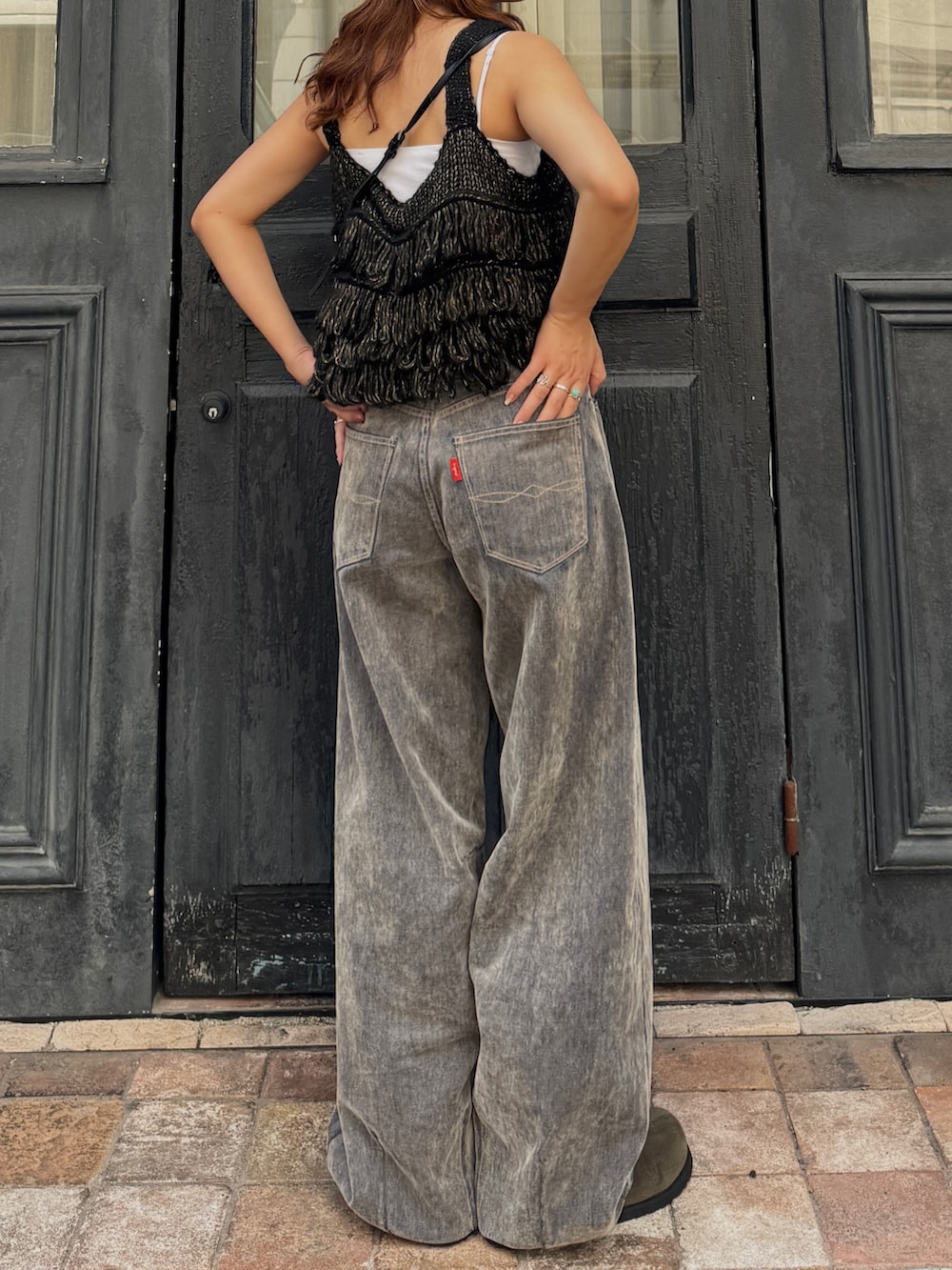 ベージュ系のデニムパンツ、ブラック系のニット/セーター、ベージュ系のスリッポンを着用したレディースの秋コーディネートの6枚目の写真