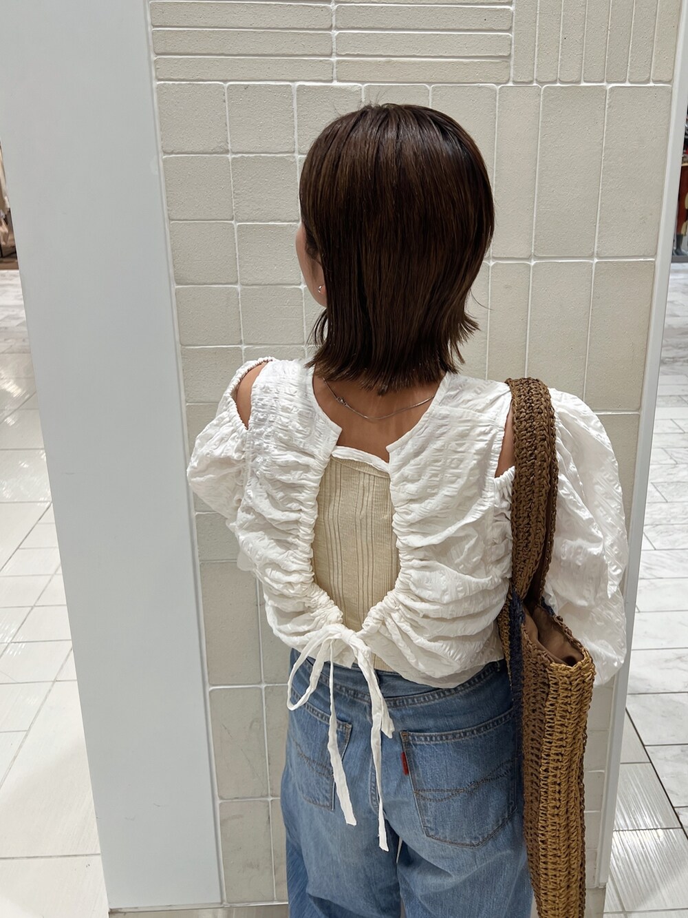 ホワイト系のシャツ/ブラウス、ブラウン系のトートバッグ、ブルー系のデニムパンツを着用したレディースの冬コーディネートの9枚目の写真