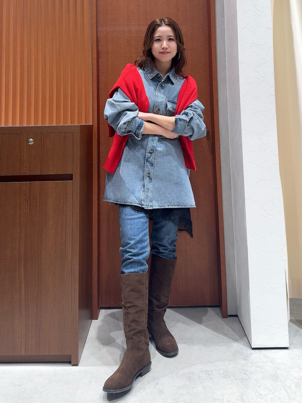 ブルー系のシャツ/ブラウス、レッド系のニット/セーター、ブラック系のキャミソールを着用したレディースの冬コーディネートの6枚目の写真