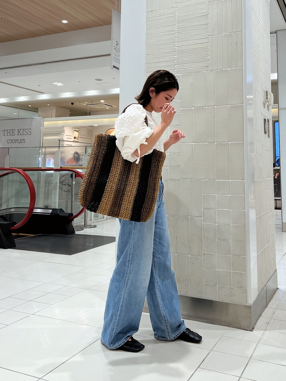 ホワイト系のシャツ/ブラウス、ブラウン系のトートバッグ、ブルー系のデニムパンツを着用したレディースの冬コーディネートの4枚目の写真