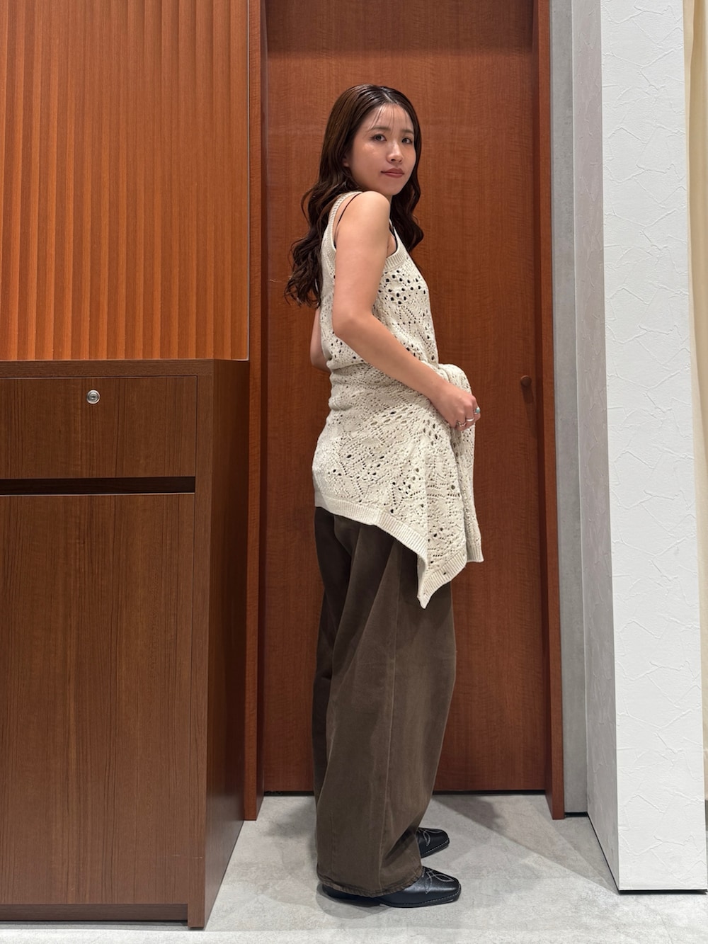 ブラウン系のデニムパンツ、ホワイト系のアンサンブル、ブラック系のその他シューズを着用したレディースの秋コーディネートの2枚目の写真