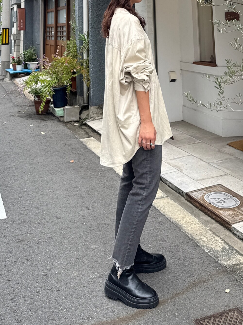 ブラック系のデニムパンツ、ホワイト系のシャツ/ブラウスを着用したレディースの秋コーディネートの7枚目の写真