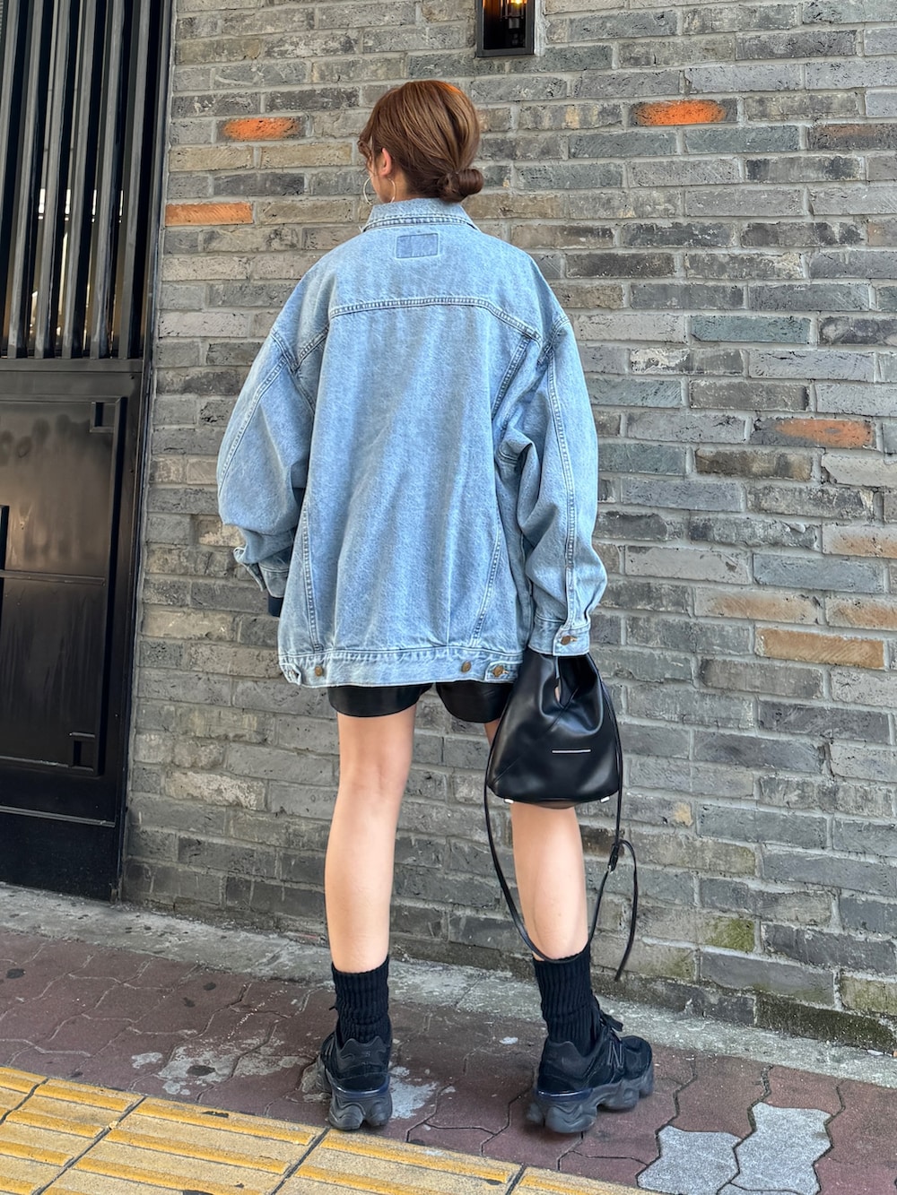 ブルー系のデニムジャケット、ブルー系のTシャツ/カットソー、ブラック系のその他パンツを着用したレディースの冬コーディネートの2枚目の写真