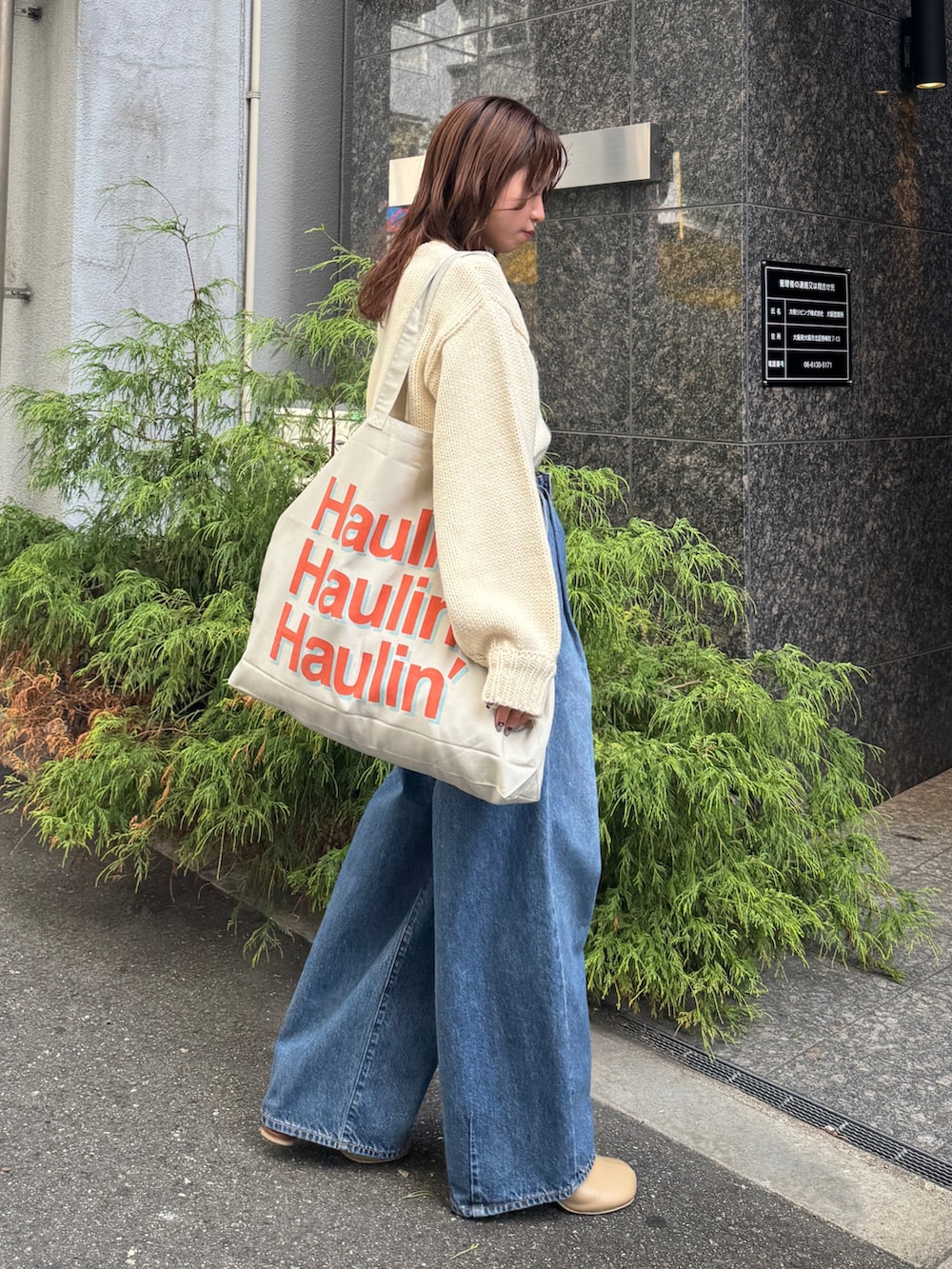 ブルー系のデニムパンツ、ホワイト系のニット/セーターを着用したレディースの秋コーディネートの6枚目の写真