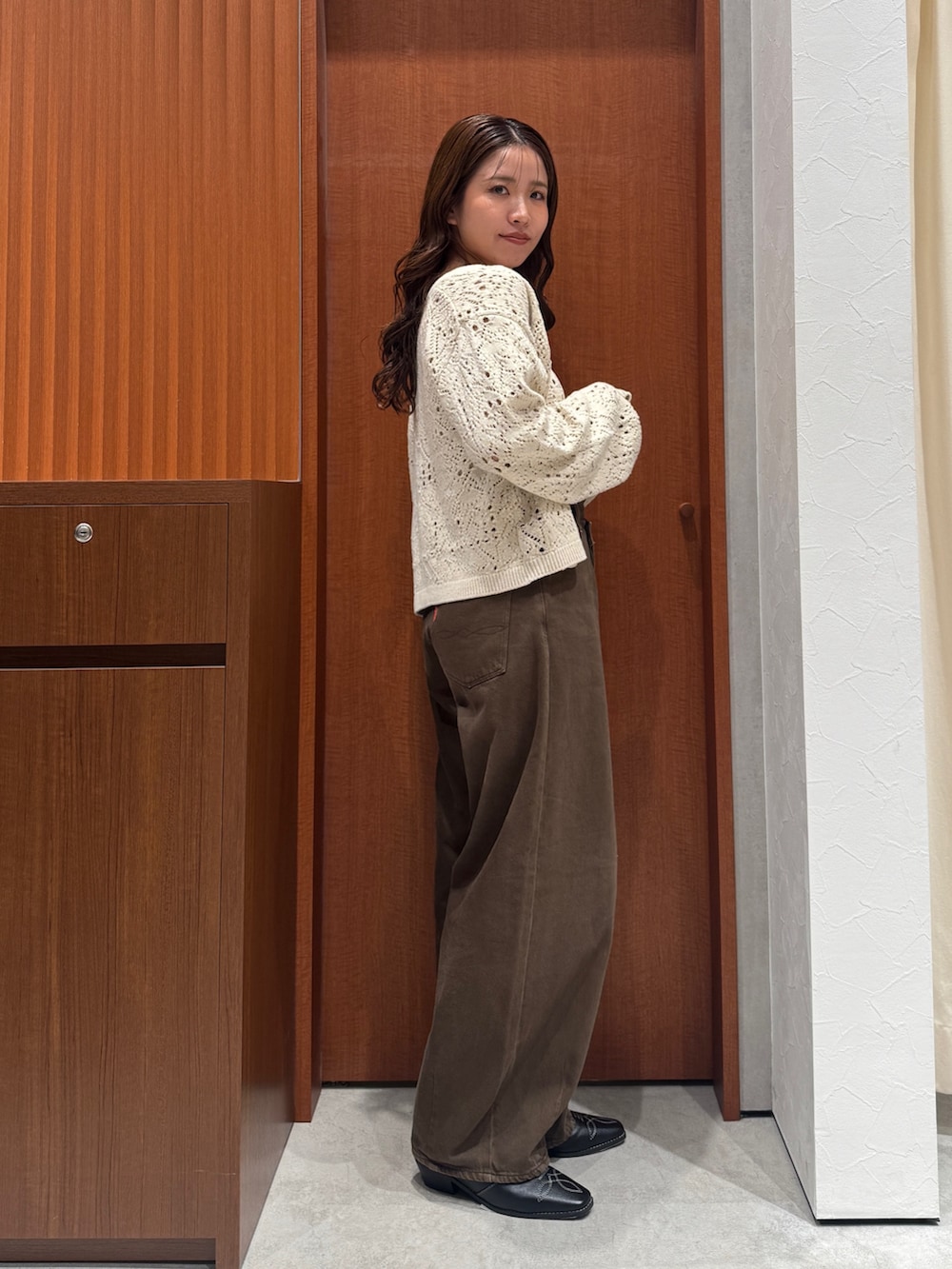 ブラウン系のデニムパンツ、ホワイト系のアンサンブル、ブラック系のその他シューズを着用したレディースの秋コーディネートの8枚目の写真