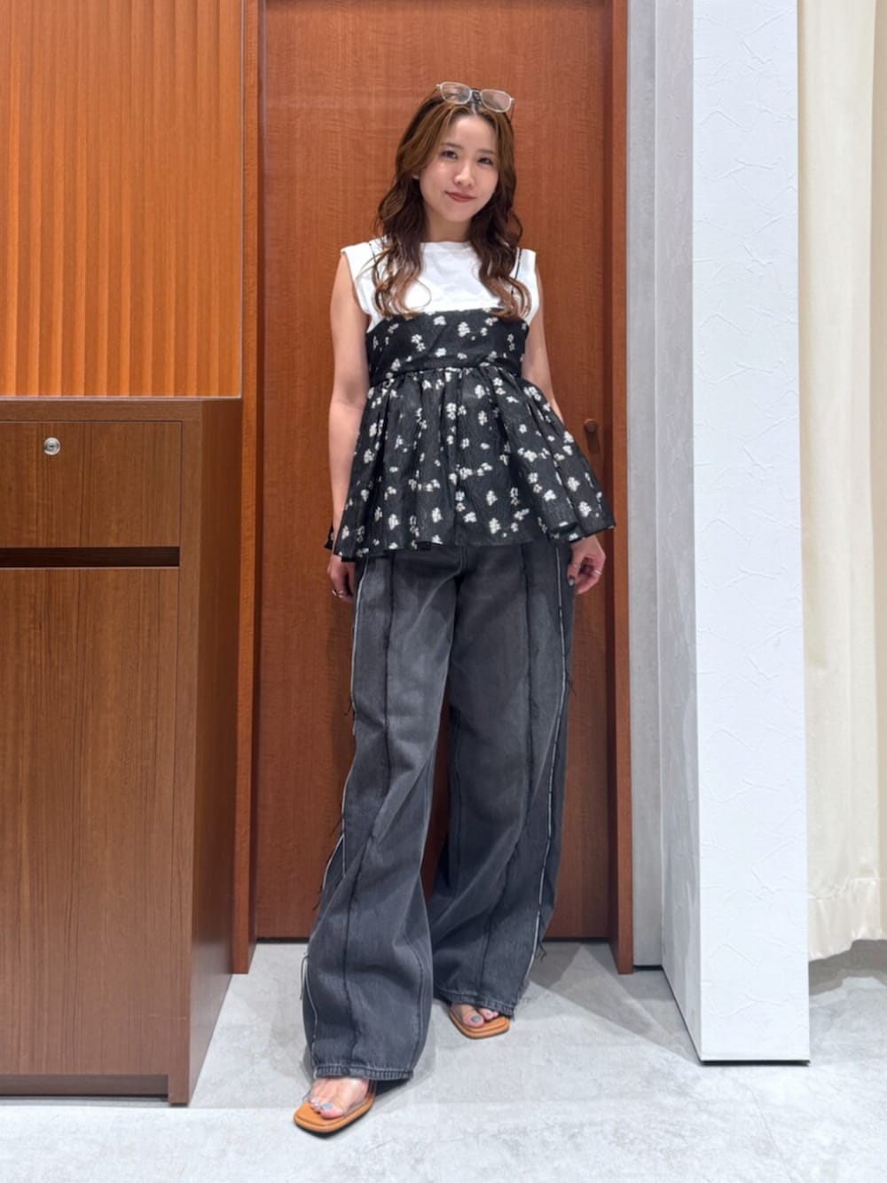 ブラック系のデニムパンツ、ブラック系のキャミソール、ホワイト系のタンクトップを着用したレディースの夏コーディネートの5枚目の写真