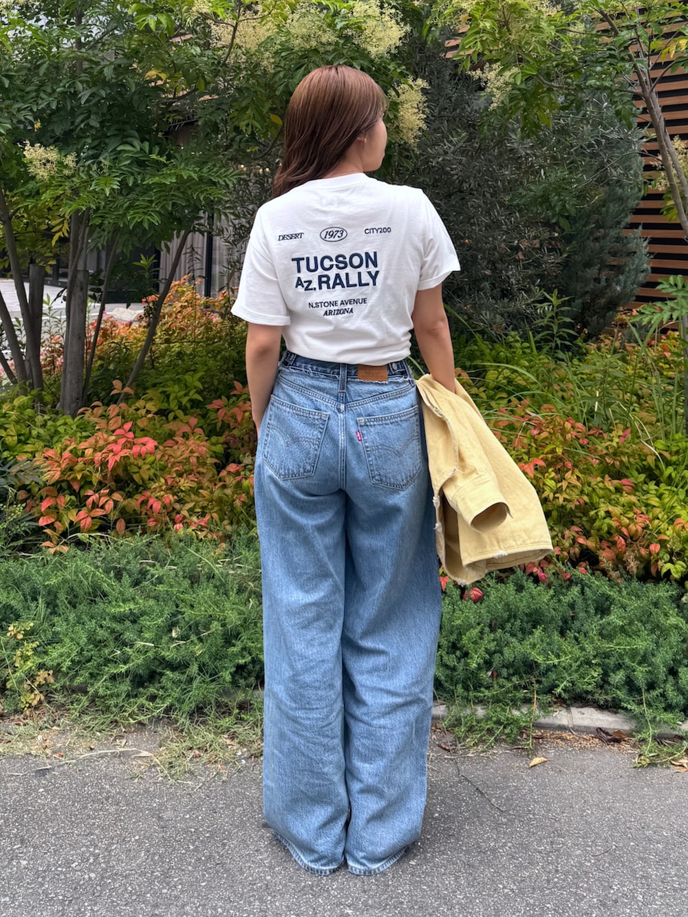ブルー系のデニムパンツ、イエロー系のブルゾン、ホワイト系のTシャツ/カットソーを着用したレディースの夏コーディネートの6枚目の写真