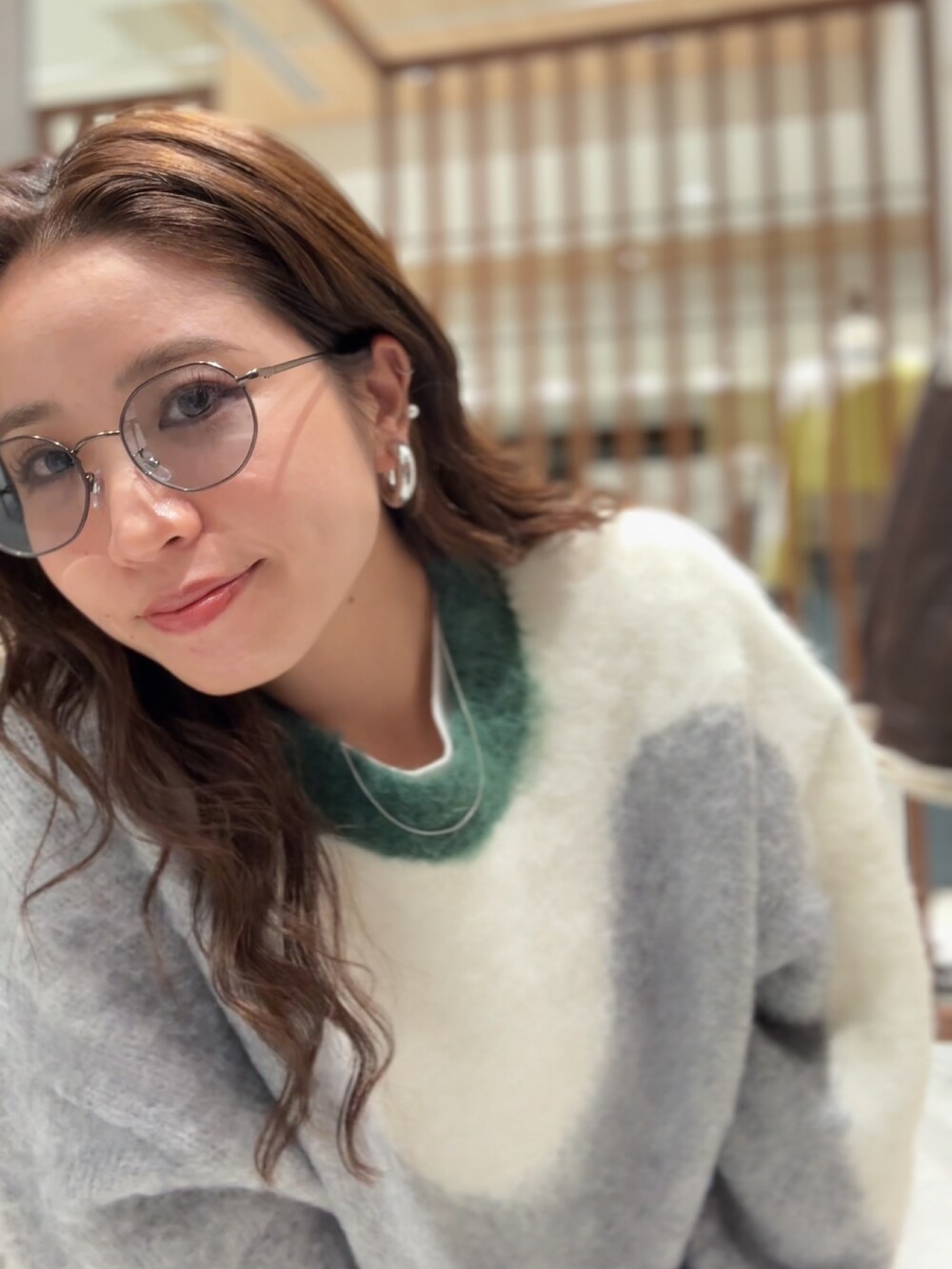 グリーン系のニット/セーター、ホワイト系のTシャツ/カットソー、ブルー系のデニムパンツを着用したレディースの秋コーディネートの10枚目の写真