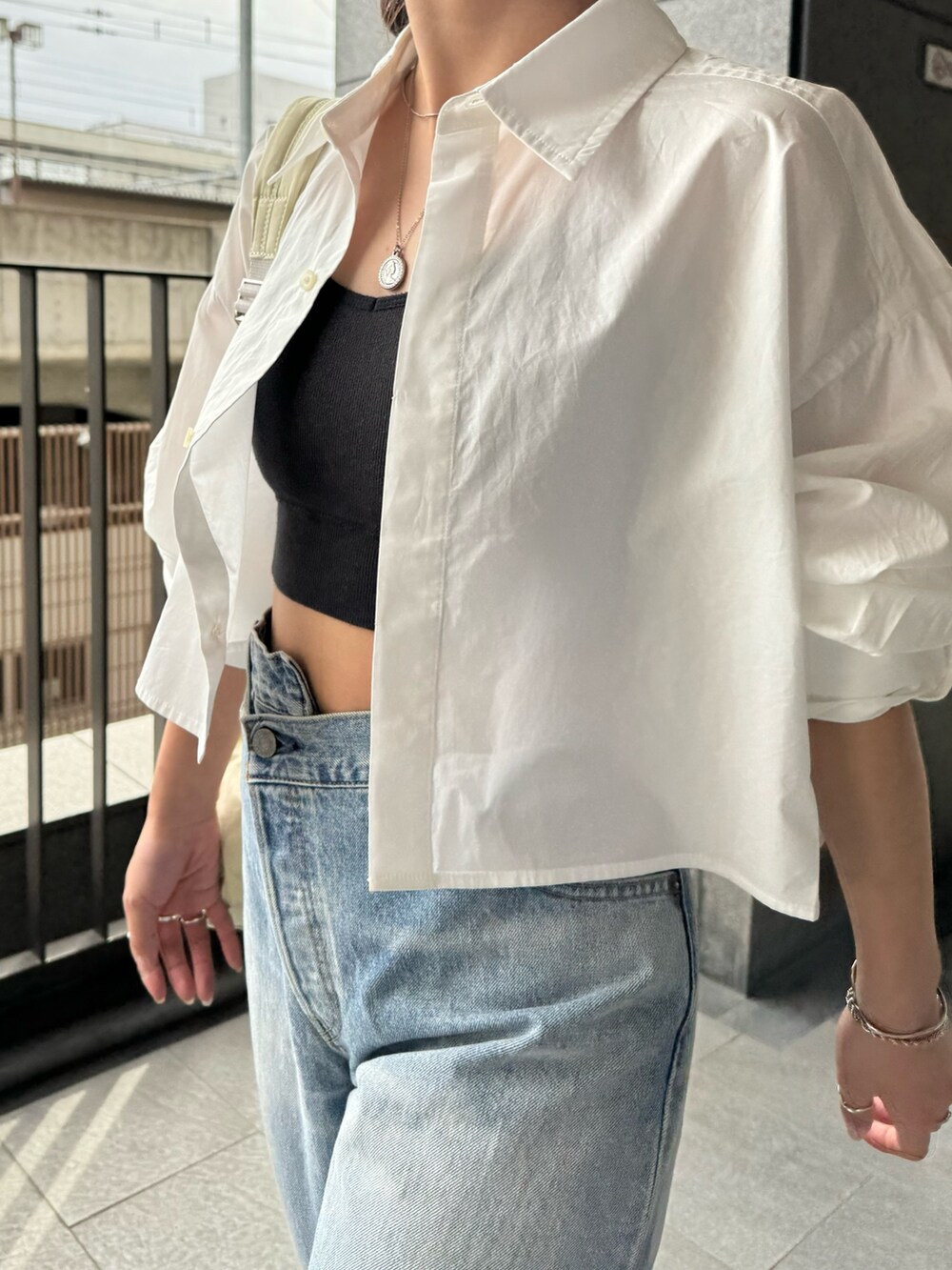 ブルー系のデニムパンツ、ホワイト系のシャツ/ブラウス、ブラック系のキャミソールを着用したレディースの春コーディネートの8枚目の写真