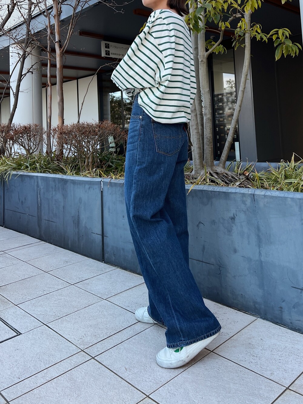 ブルー系のデニムパンツ、グリーン系のTシャツ/カットソーを着用したレディースの冬コーディネートの3枚目の写真