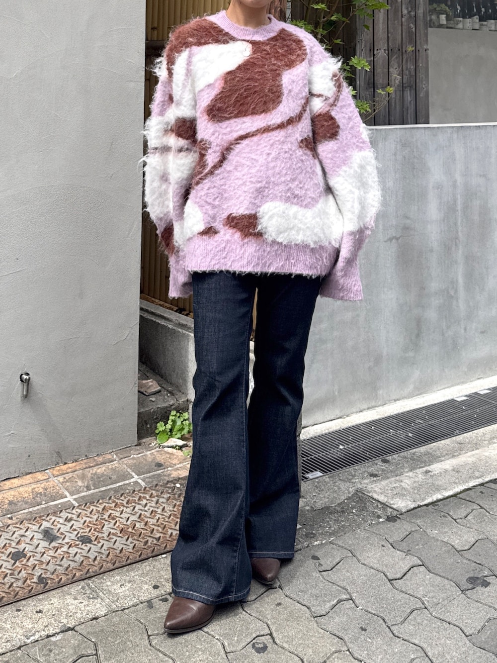 ブルー系のデニムパンツ、ブラウン系のブーツ、ピンク系のニット/セーターを着用したレディースの秋コーディネートの6枚目の写真