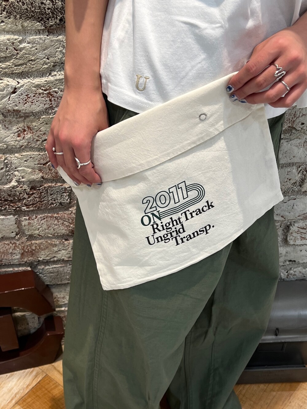 ベージュ系のその他パンツ、ブラック系のサンダル、イエロー系のネックレスを着用したレディースの春コーディネートの9枚目の写真