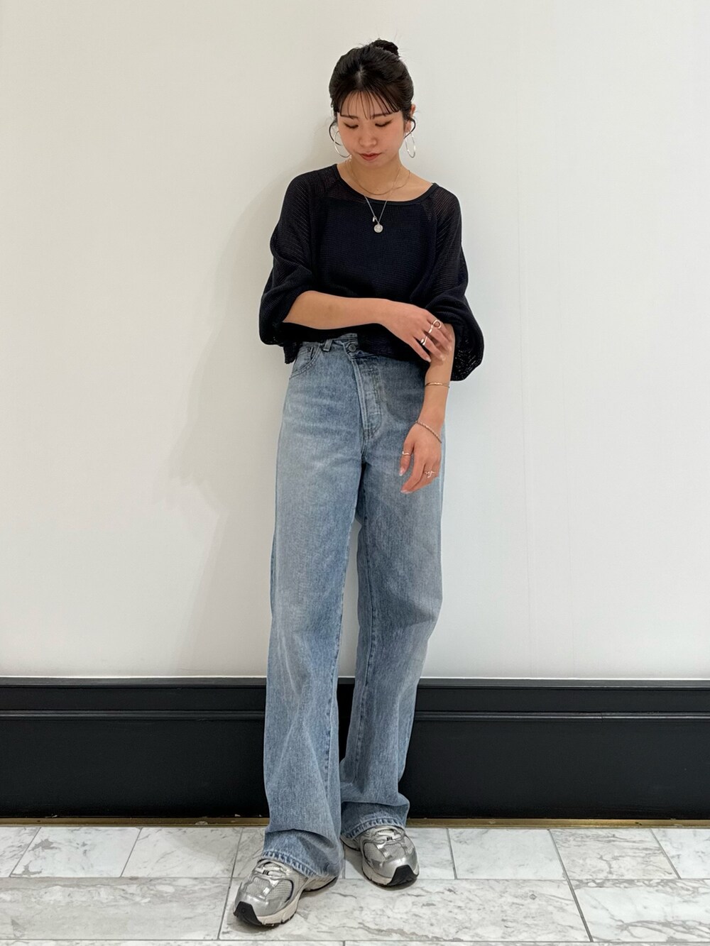 ブラック系のキャミソール、グレー系のTシャツ/カットソー、ブルー系のデニムパンツを着用したレディースの春コーディネートの5枚目の写真