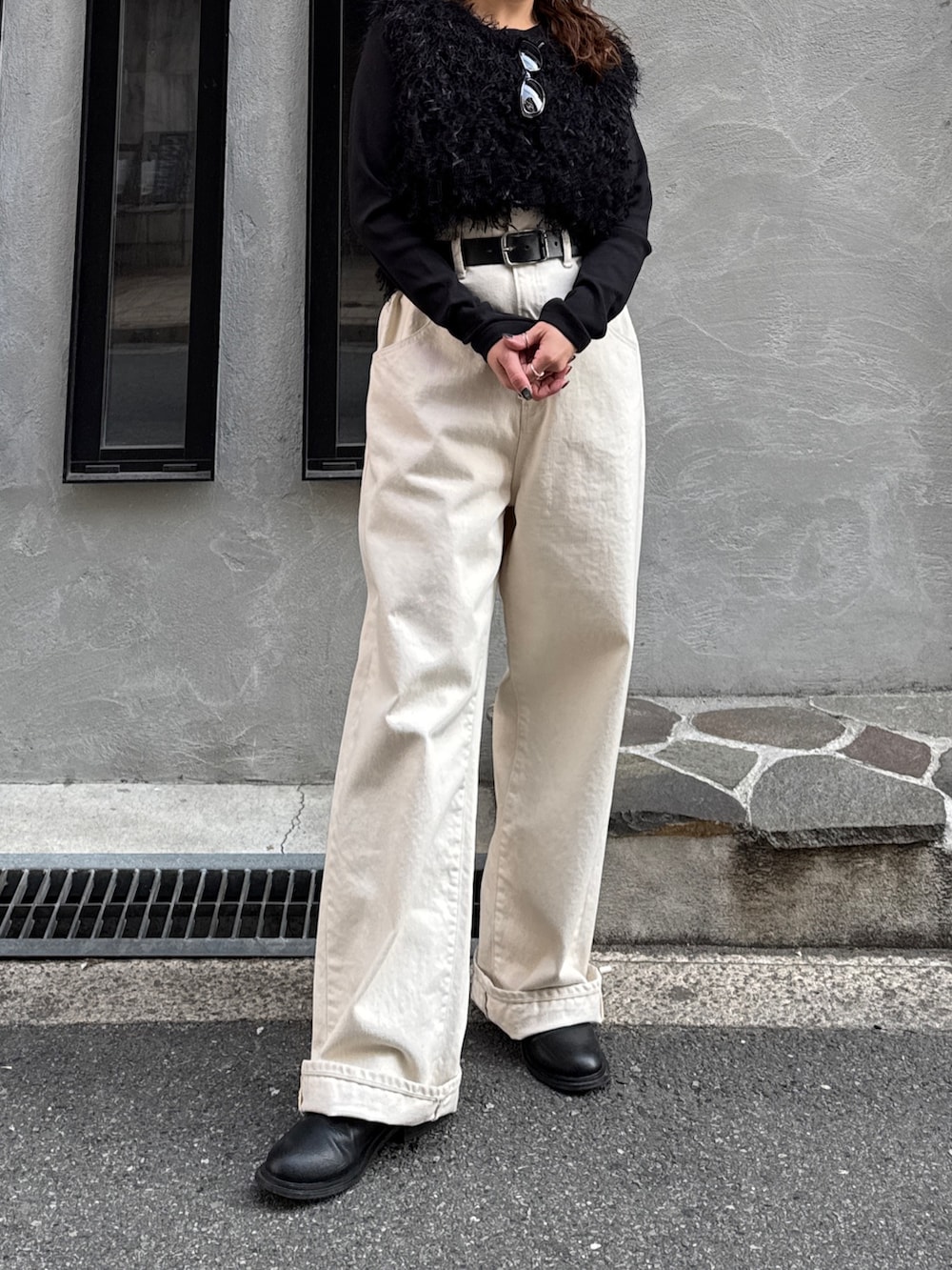 ホワイト系のデニムパンツ、ブラック系のニット/セーター、ブラック系のTシャツ/カットソーを着用したレディースの冬コーディネートの6枚目の写真