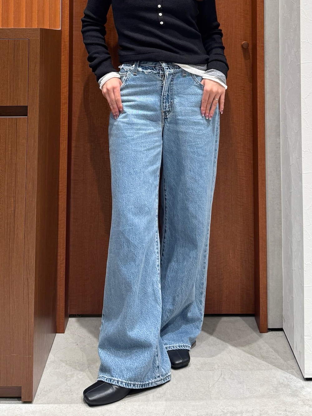 ブルー系のデニムパンツ、ブラック系のニット/セーターを着用したレディースの秋コーディネートの5枚目の写真
