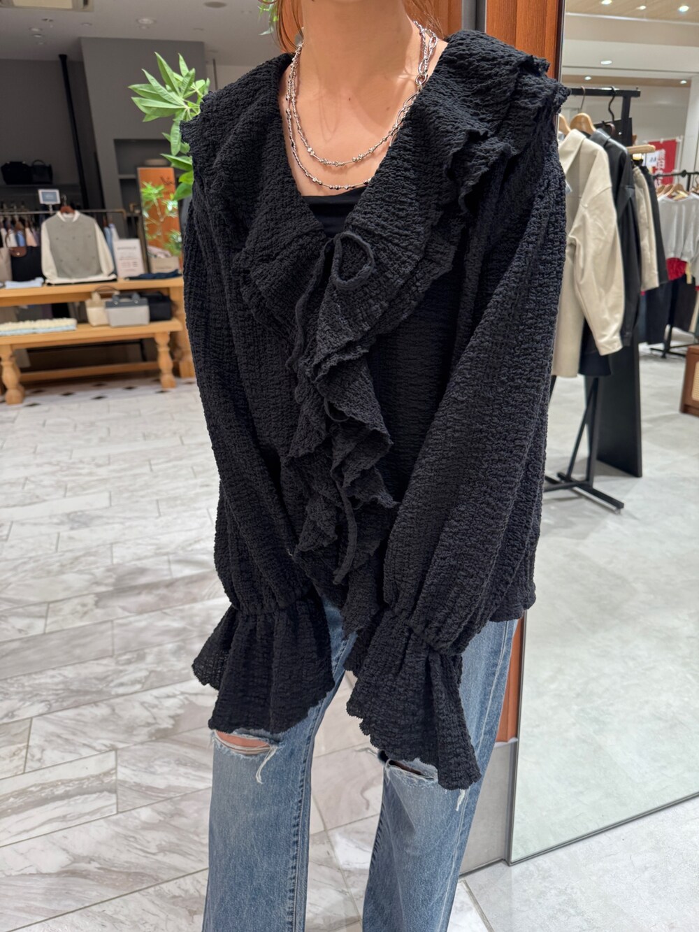 ブルー系のデニムパンツ、ブラック系のシャツ/ブラウス、ホワイト系のパンプスを着用したレディースの春コーディネートの9枚目の写真