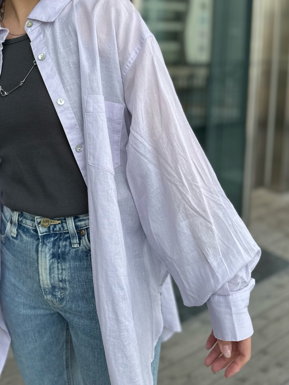 グレー系のTシャツ/カットソー、ブルー系のデニムパンツ、ブラック系のサンダルを着用したレディースの春コーディネートの8枚目の写真