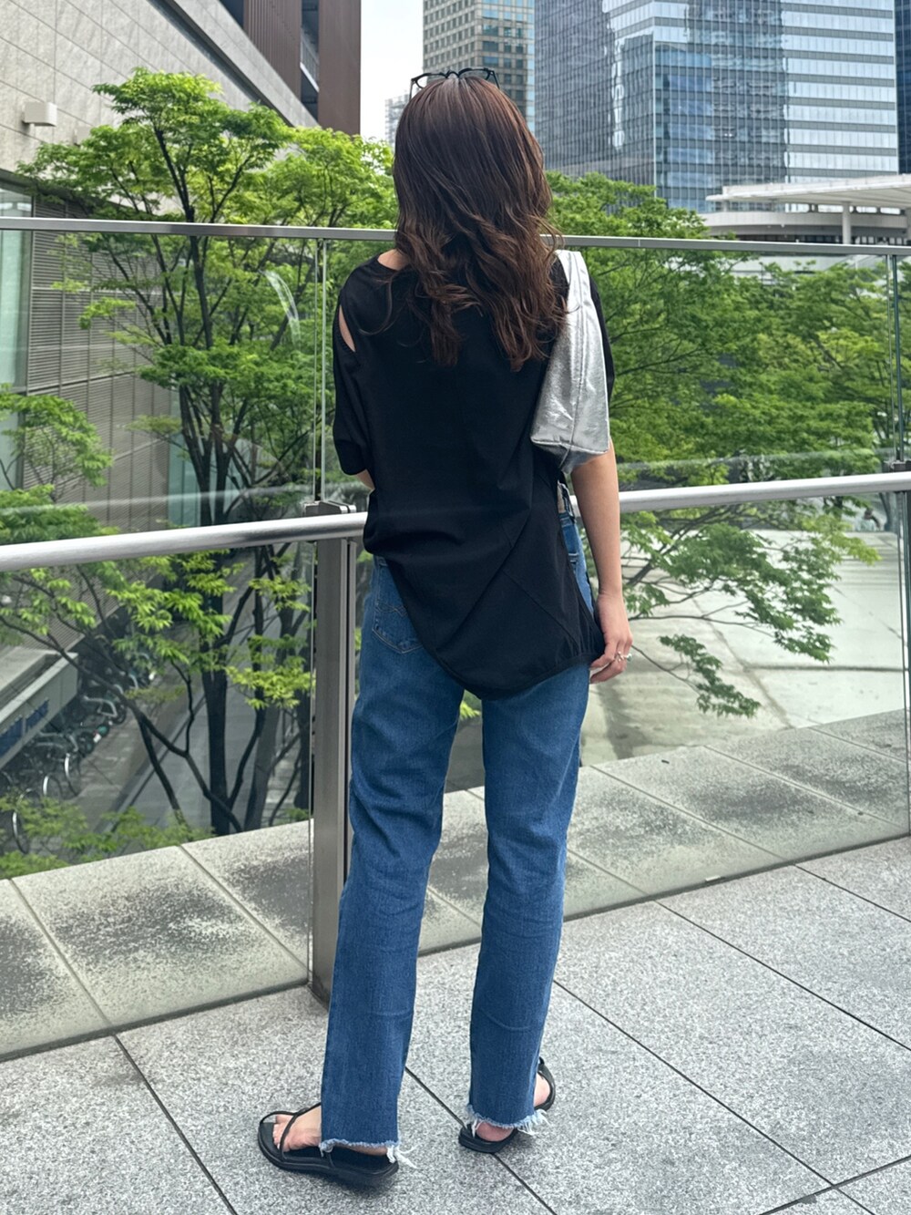 ブラック系のTシャツ/カットソー、ブルー系のデニムパンツを着用したレディースの春コーディネートの9枚目の写真