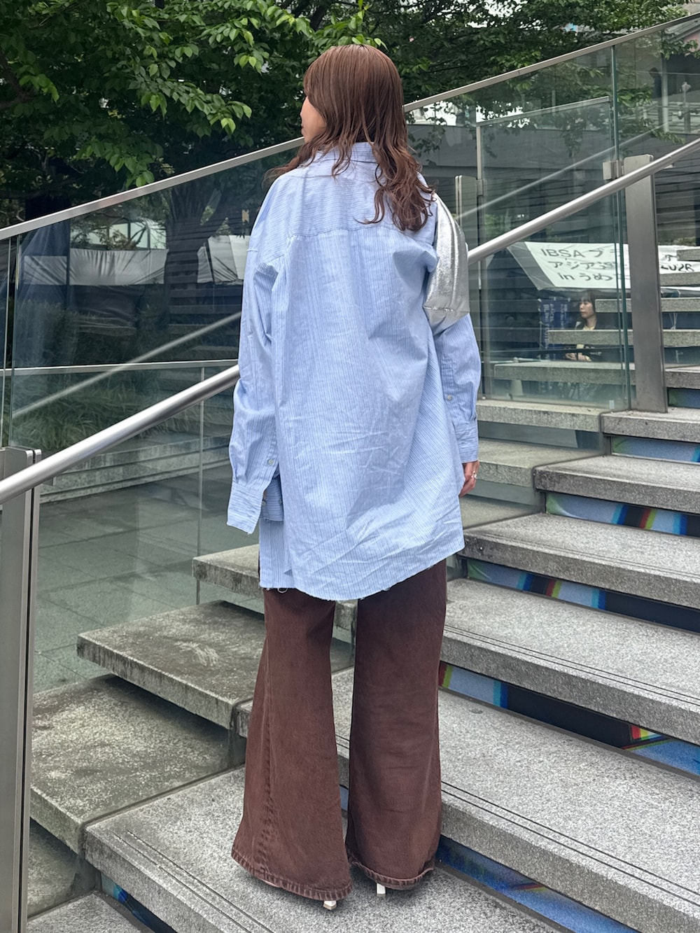 ブラウン系のデニムパンツ、ブルー系のシャツ/ブラウスを着用したレディースの春コーディネートの6枚目の写真