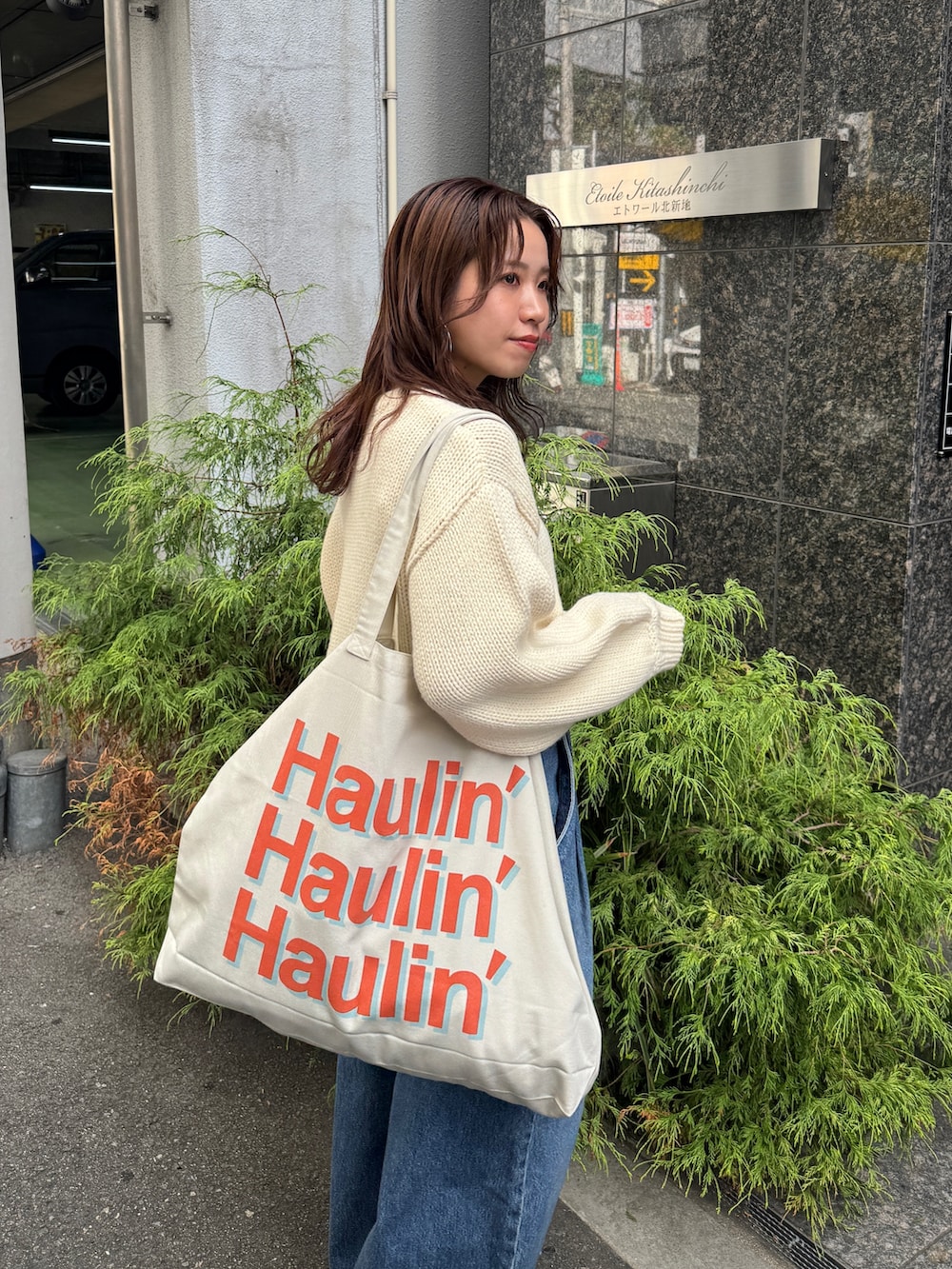 ブルー系のデニムパンツ、ホワイト系のニット/セーターを着用したレディースの秋コーディネートの9枚目の写真