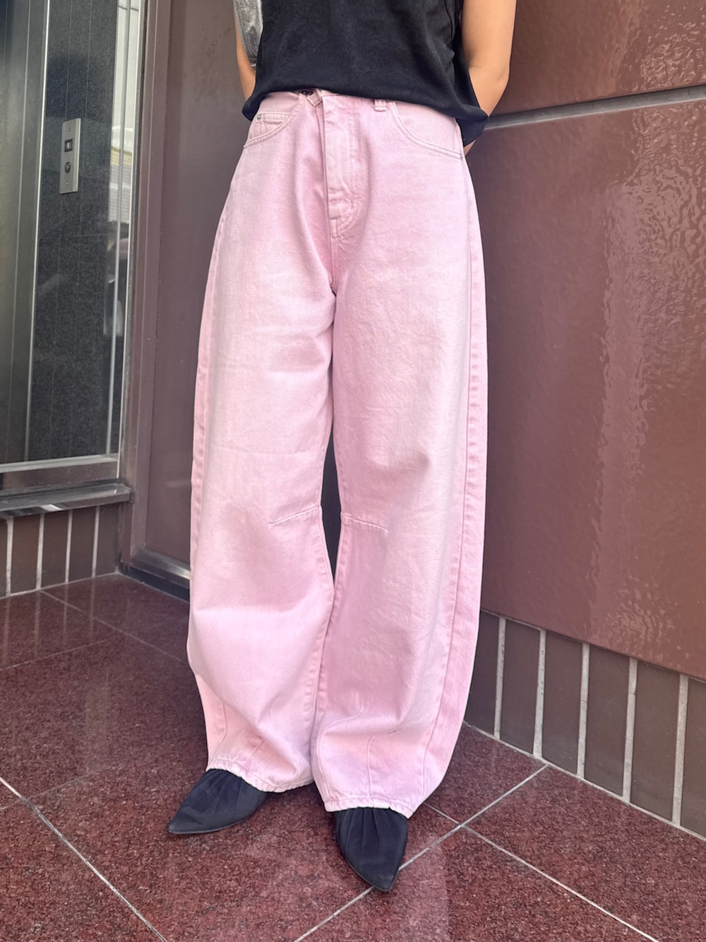 ブルー系のパーカー、ピンク系のデニムパンツ、ブラック系のキャミソールを着用したレディースの春コーディネートの6枚目の写真