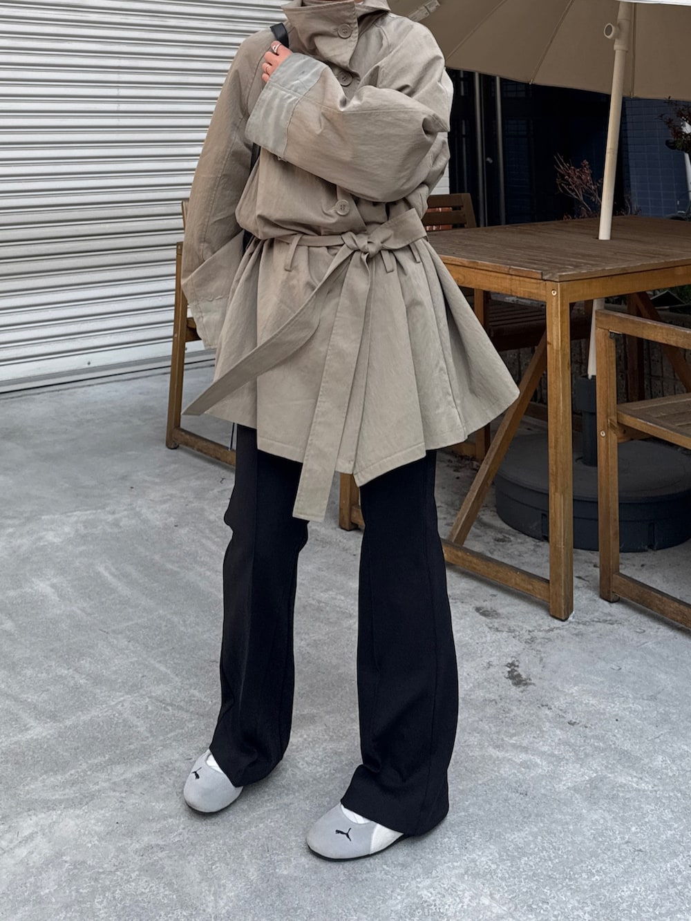 グリーン系のトレンチコート、ブラック系のその他パンツを着用したレディースの冬コーディネートの2枚目の写真