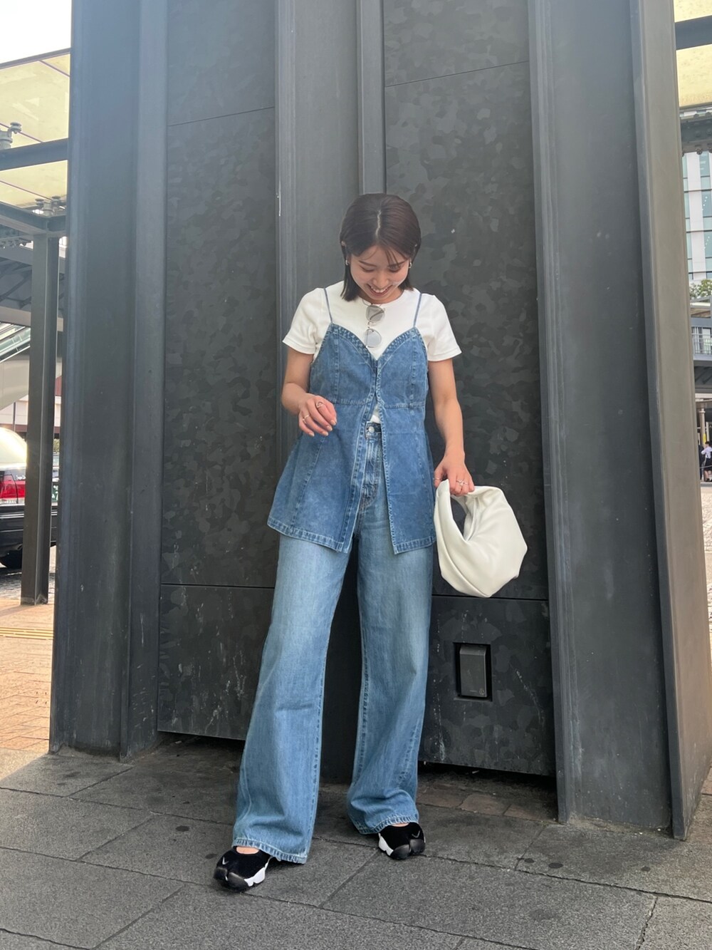 ブルー系のデニムパンツ、ホワイト系のTシャツ/カットソー、ブルー系のキャミソールを着用したレディースの春コーディネートの3枚目の写真