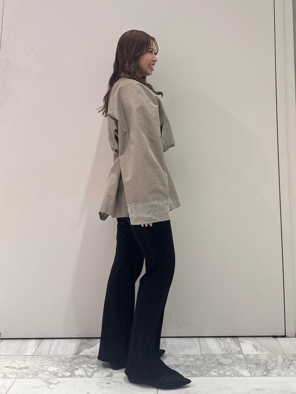 グリーン系のトレンチコート、ブラック系のその他パンツ、ブラック系のパンプスを着用したレディースの春コーディネートの4枚目の写真