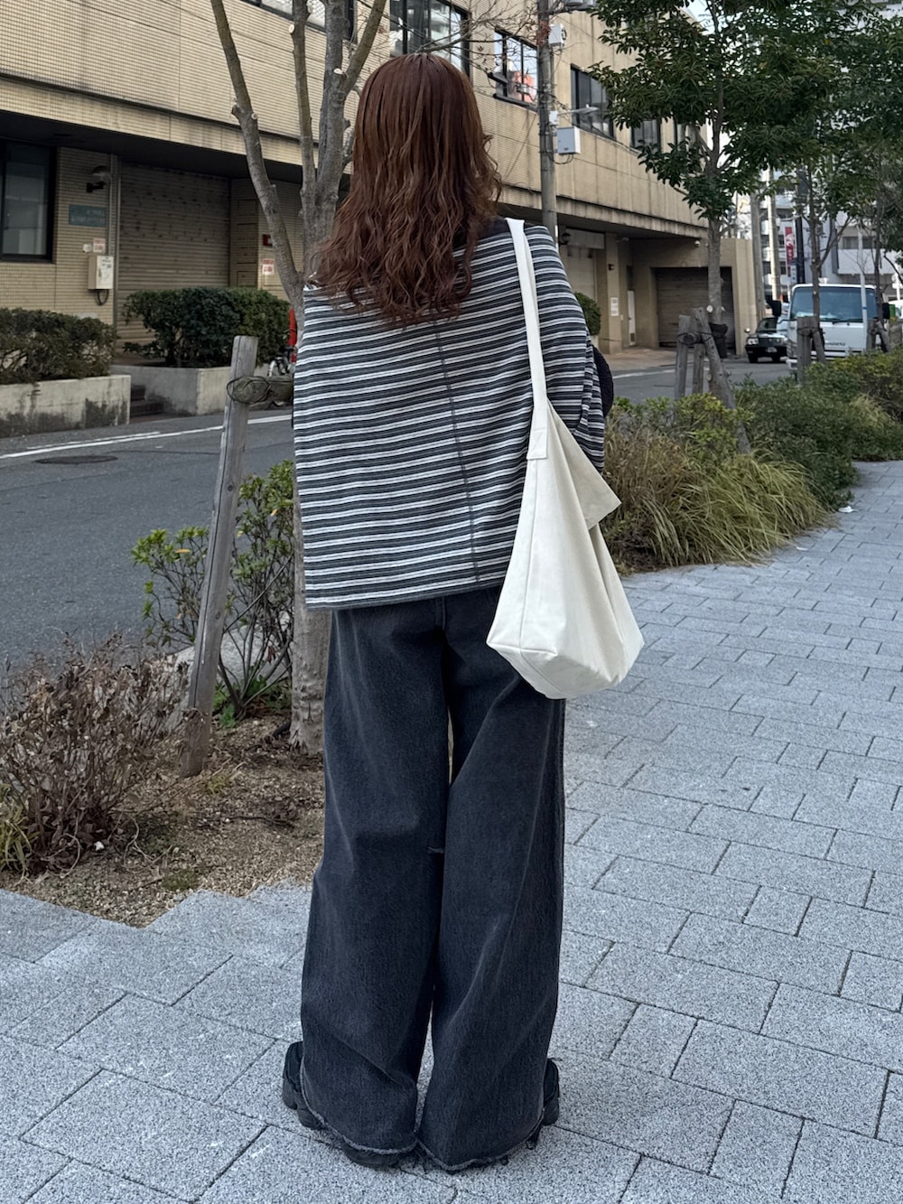 グレー系のニット/セーター、グレー系のTシャツ/カットソー、ブラック系のデニムパンツを着用したレディースの冬コーディネートの4枚目の写真