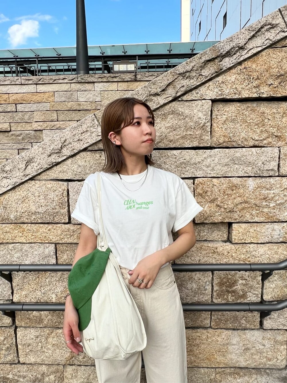 ホワイト系のデニムパンツ、ホワイト系のTシャツ/カットソー、グリーン系のキャップを着用したレディースの春コーディネートの5枚目の写真