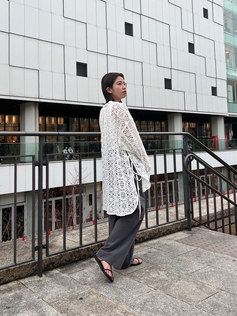 ホワイト系のシャツ/ブラウス、グレー系のその他パンツ、ブラック系のサンダルを着用したレディースの春コーディネートの5枚目の写真