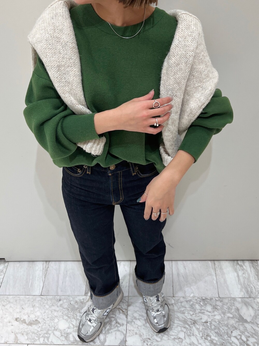 グリーン系のニット/セーター、ホワイト系のニット/セーターを着用したレディースの冬コーディネートの4枚目の写真