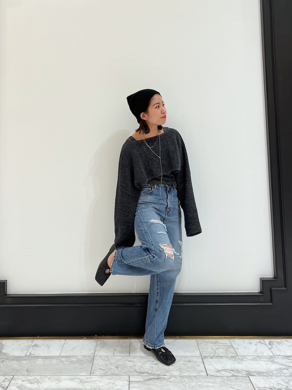 ブルー系のデニムパンツ、グレー系のニット/セーター、ブラック系のパンプスを着用したレディースの春コーディネートの3枚目の写真