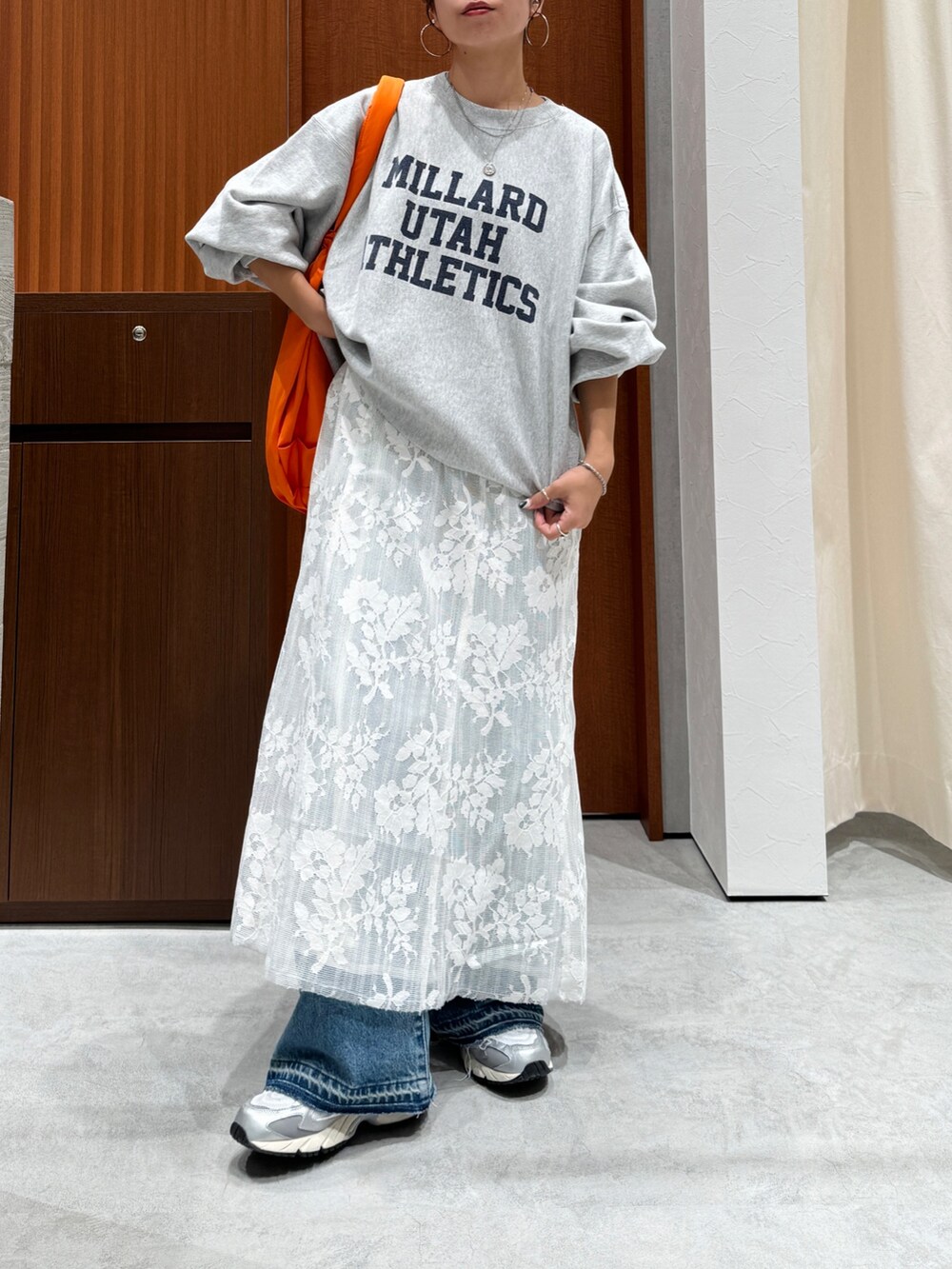 ホワイト系のワンピース、グレー系のスウェット、ブルー系のデニムパンツを着用したレディースの秋コーディネートの10枚目の写真