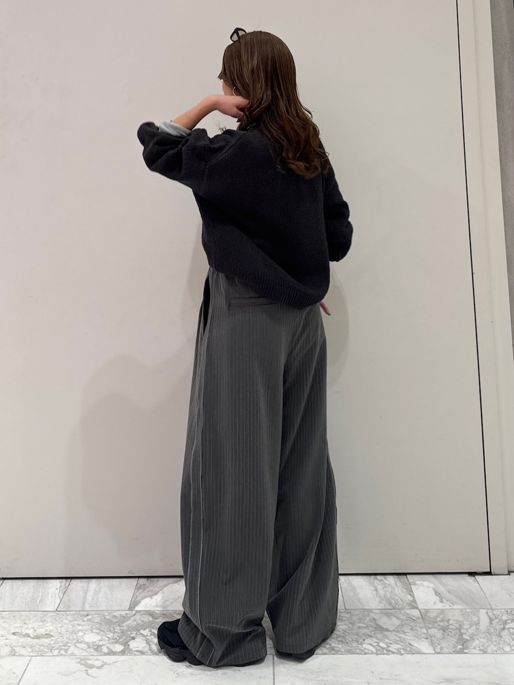 グレー系のその他パンツ、グレー系のニット/セーター、ブルー系のTシャツ/カットソーを着用したレディースの冬コーディネートの7枚目の写真