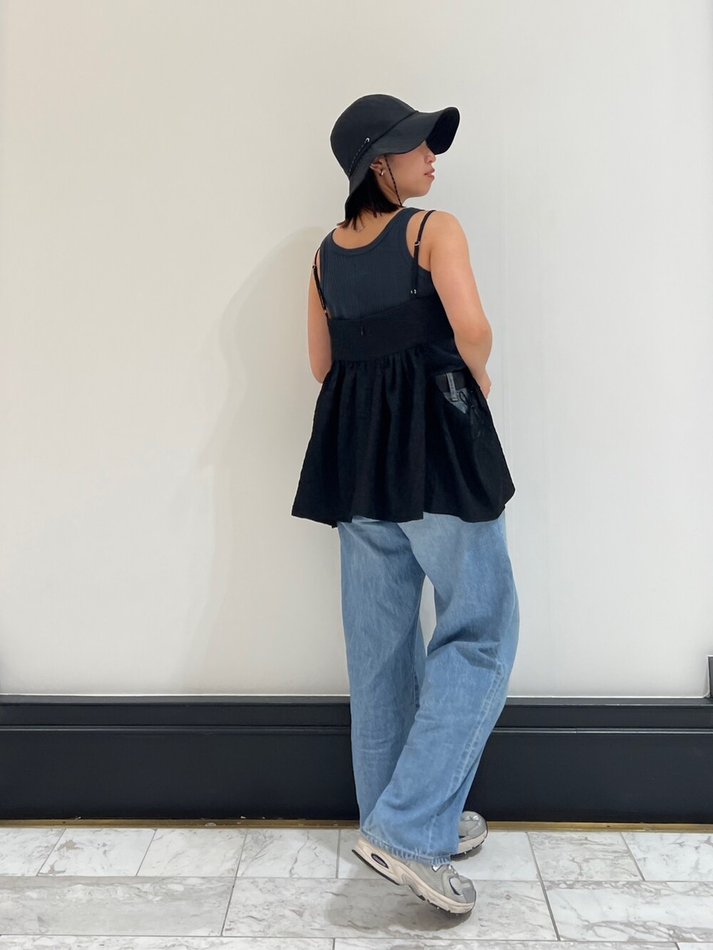 グレー系のタンクトップ、ブルー系のデニムパンツ、ブラック系のシャツ/ブラウスを着用したレディースの春コーディネートの3枚目の写真