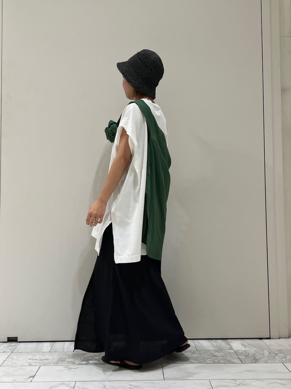 ブラック系のサンダル、ホワイト系のTシャツ/カットソー、グリーン系のシャツ/ブラウスを着用したレディースの夏コーディネートの3枚目の写真