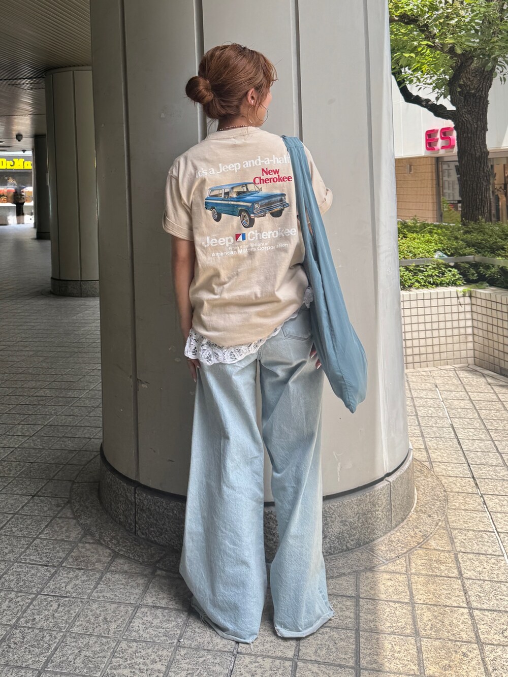 ブルー系のデニムパンツ、ブルー系のトートバッグ、ホワイト系のシャツ/ブラウスを着用したレディースの夏コーディネートの3枚目の写真