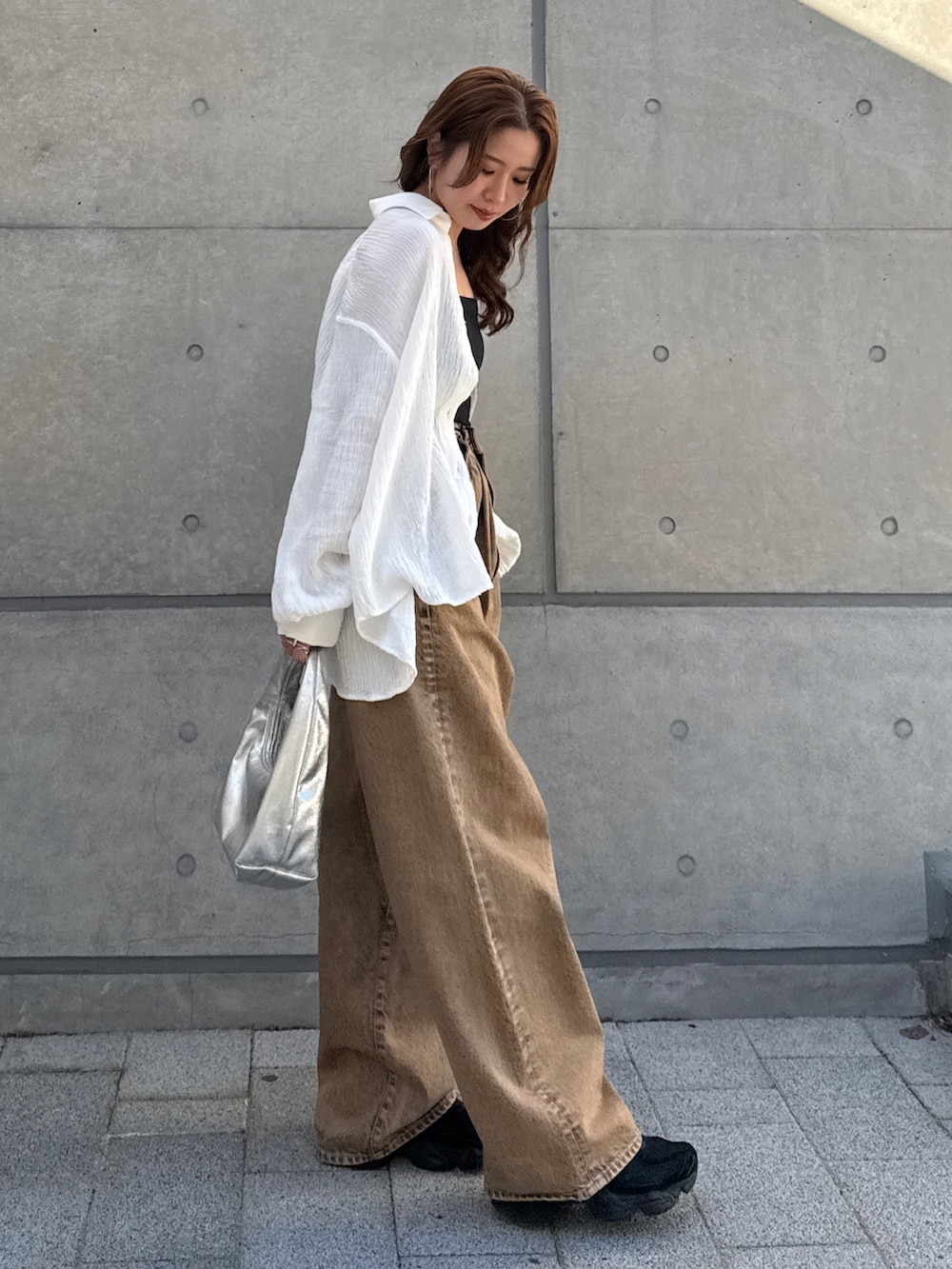 ブラウン系のデニムパンツ、ホワイト系のシャツ/ブラウスを着用したレディースの春コーディネートの2枚目の写真