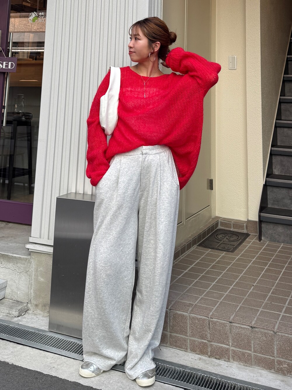 グレー系のスウェットパンツ、レッド系のニット/セーターを着用したレディースの秋コーディネートの2枚目の写真