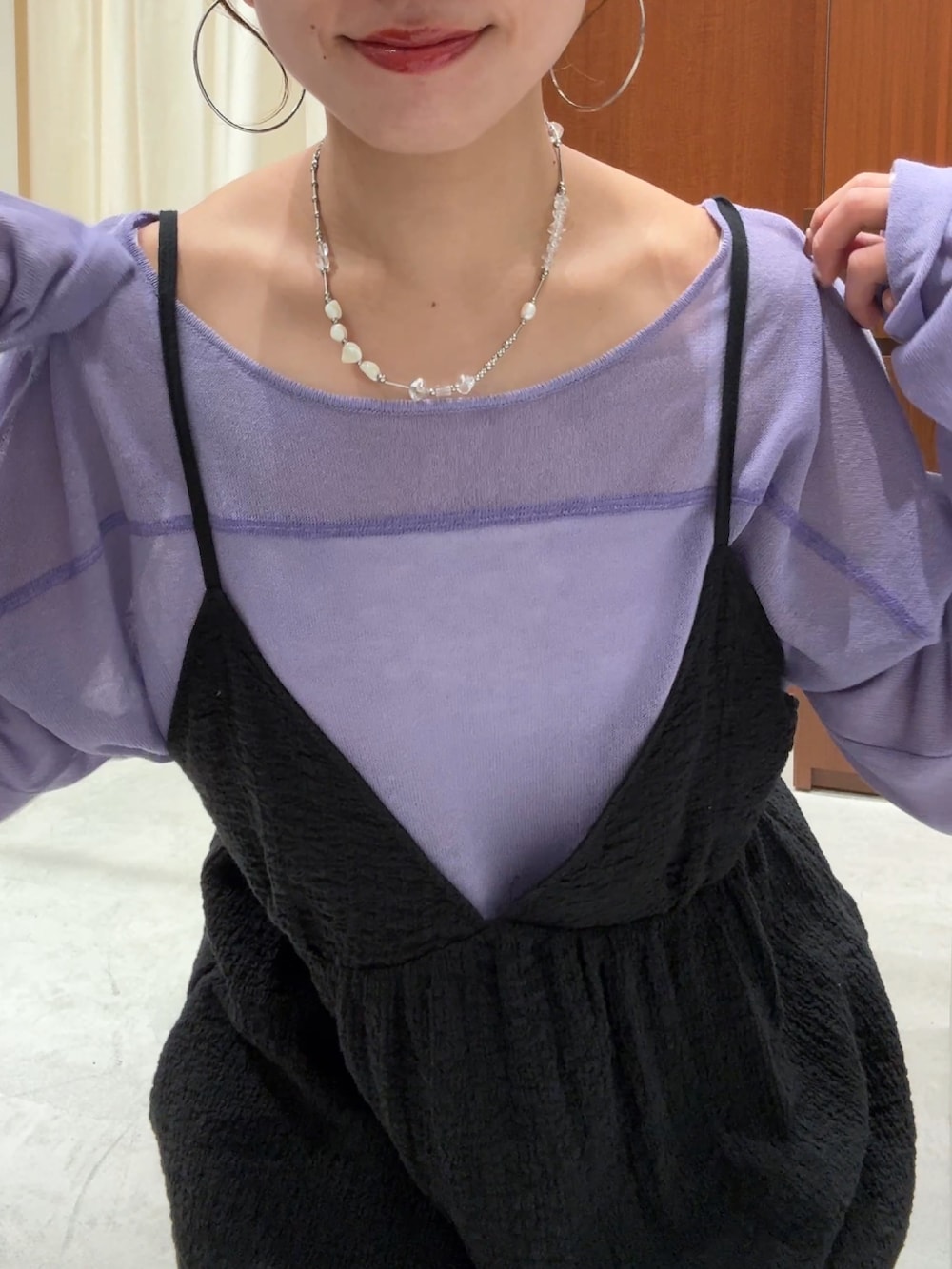 ブラック系のワンピース、パープル系のニット/セーター、ブルー系のデニムパンツを着用したレディースの春コーディネートの10枚目の写真