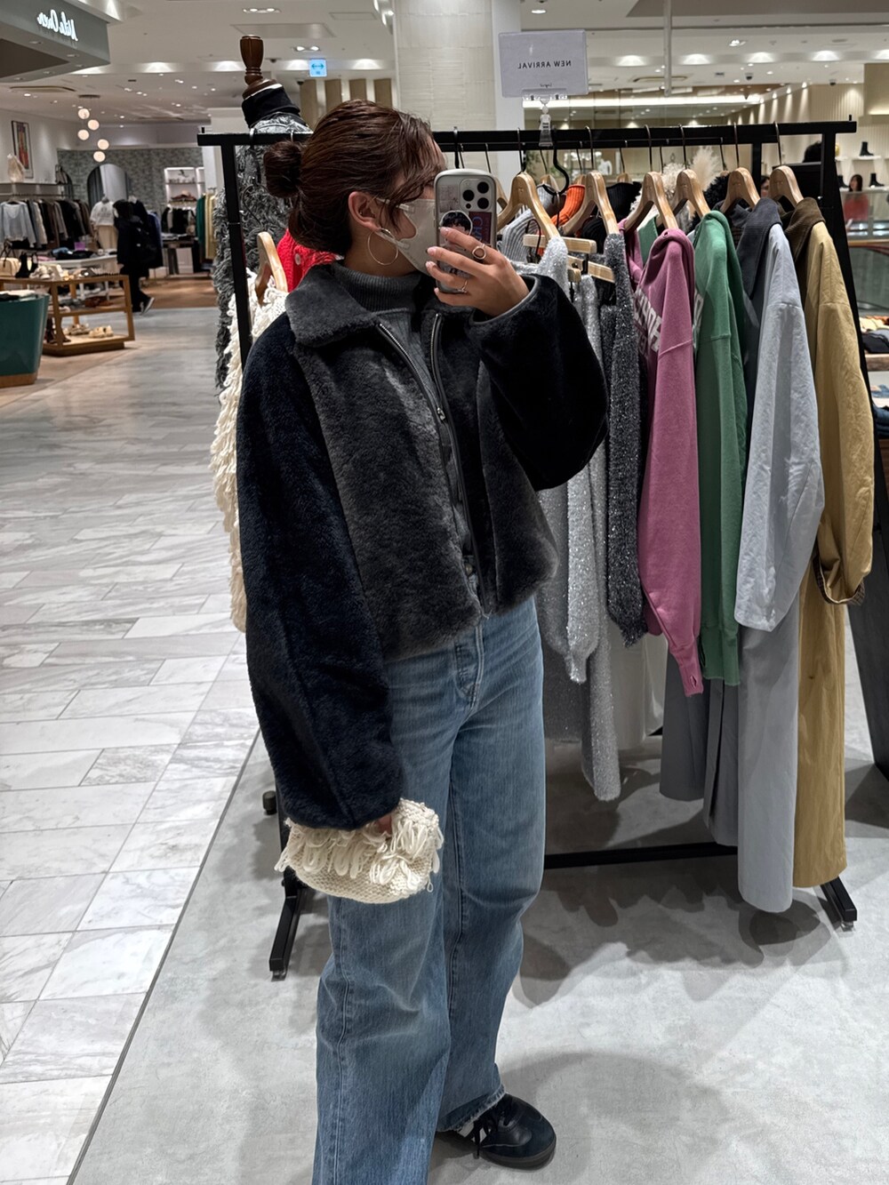 グレー系のブルゾン、グレー系のニット/セーター、ブルー系のデニムパンツを着用したレディースの秋コーディネートの5枚目の写真