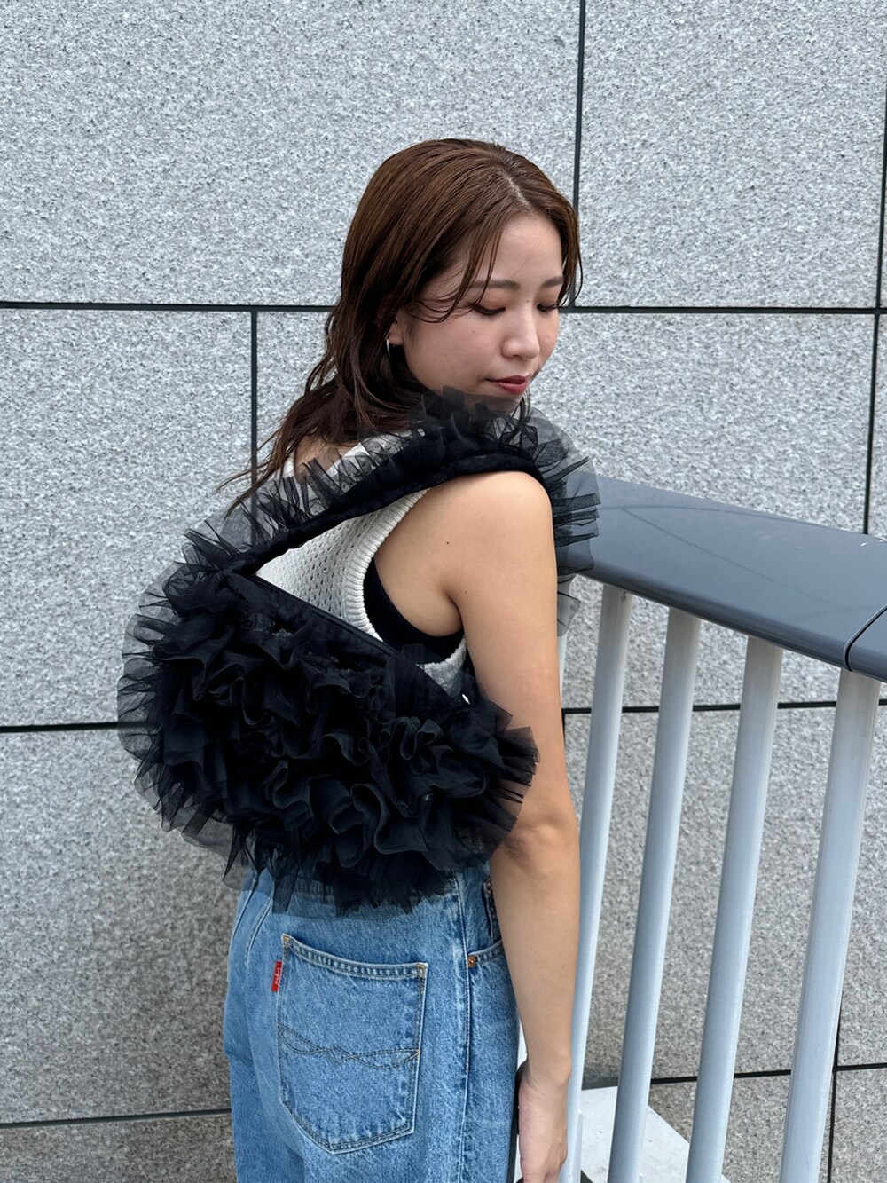 ブルー系のデニムパンツ、ホワイト系のニット/セーター、ブラック系のショルダーバッグを着用したレディースの秋コーディネートの8枚目の写真