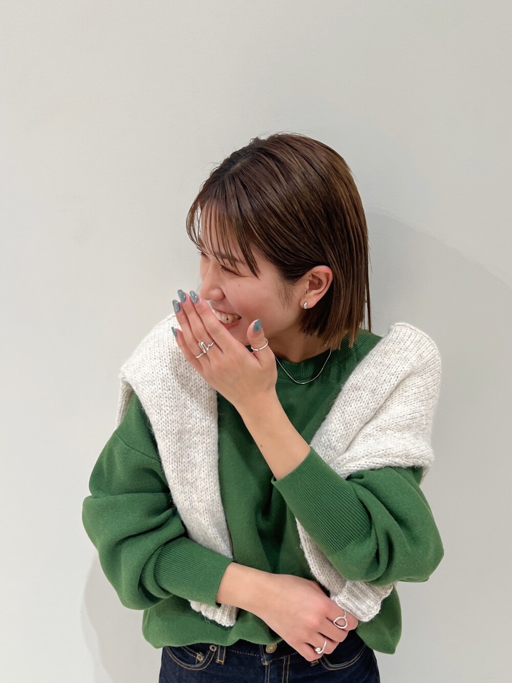 グリーン系のニット/セーター、ホワイト系のニット/セーターを着用したレディースの冬コーディネートの6枚目の写真