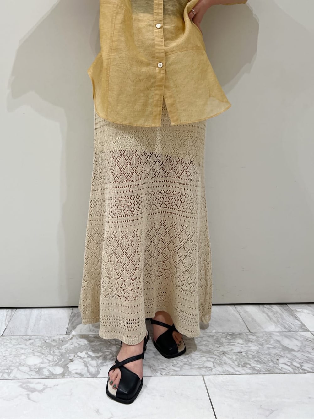 ブラウン系のシャツ/ブラウス、ベージュ系のスカート、ブラック系のサンダルを着用したレディースの春コーディネートの5枚目の写真