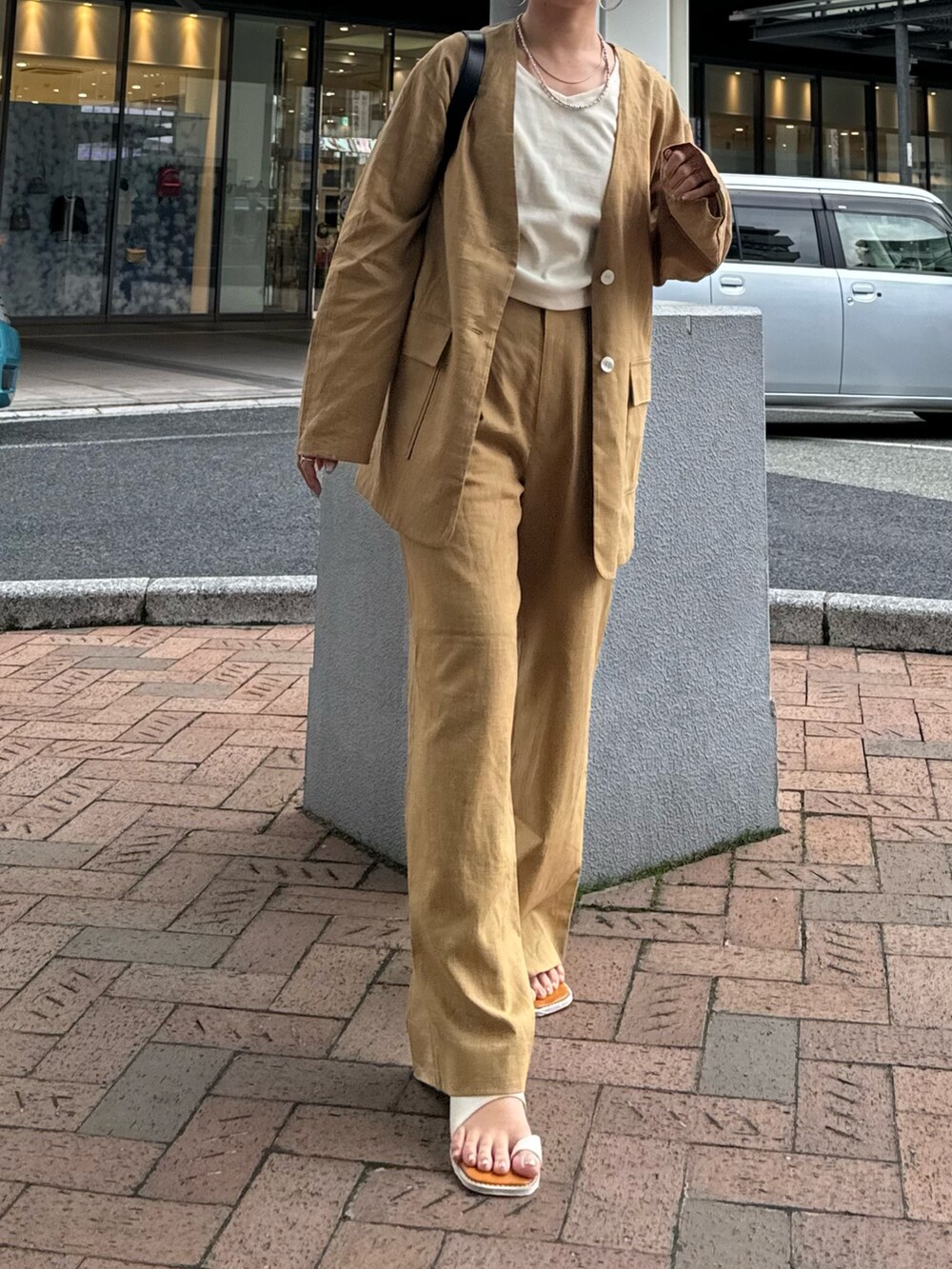 ベージュ系のテーラードジャケット、ベージュ系のその他パンツ、ホワイト系のTシャツ/カットソーを着用したレディースの春コーディネートの2枚目の写真