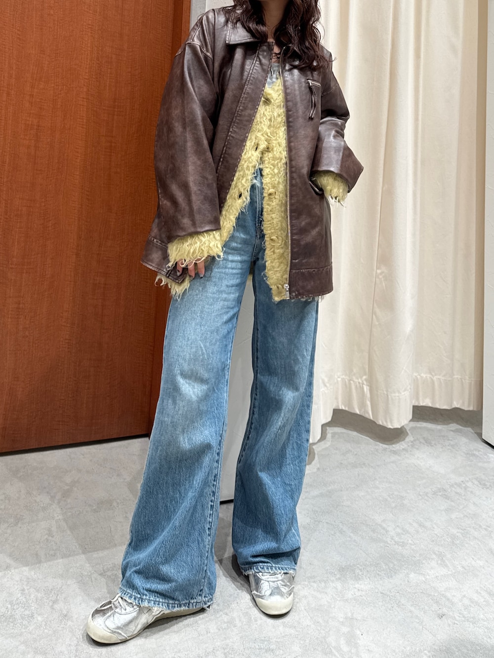 ブルー系のデニムパンツ、イエロー系のカーディガン/ボレロ、ブラウン系のブルゾンを着用したレディースの秋コーディネートの3枚目の写真